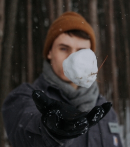 Man tossing a snowball in the air.